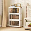 A stack of three white storage boxes with clear doors and brown handles, filled with books and other items, placed next to a sofa and a floor lamp in a room. Voir les images du produit