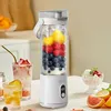 A portable electric juicer filled with fruits and ice, placed on a table with drinks and fruit slices. Produktbild-Vorschau
