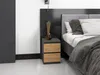 A modern nightstand with two drawers next to a bed. Produktbild-Vorschau