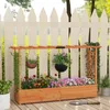 A wooden raised garden bed with flowers and hanging plants is set up on a wooden deck in front of a white picket fence. Anteprima dell’immagine prodotto