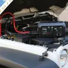 A car battery jump starter is connected to a car engine under the hood. Produktbild-Vorschau