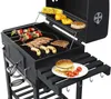 A charcoal grill with food cooking on it, including skewers, shrimp, sausages, and burgers. There is also corn and bell peppers on a warming rack. Podgląd zdjęcia produktu