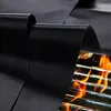 A black grill mat is shown partially covering a grill with flames underneath. Náhľad obrázku produktu