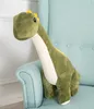 A green plush dinosaur toy sitting on a light blue chair. Náhled obrázku produktu