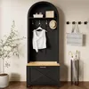 A black arched hall tree with a wooden bench and drawer, styled with a white top, hat, and basket on the shelf, and a plant and umbrella stand nearby. Produktbild-Vorschau