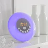 A digital alarm clock with a purple light is displayed on a white surface, with two white vases in the background. Produktbild-Vorschau