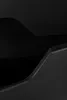A close-up abstract view of a black furniture piece, showing curves and edges. Voir les images du produit