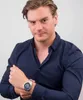 A man wearing a dark blue shirt and a silver watch. Náhľad obrázku produktu