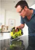 A man wearing safety glasses uses a yellow and black Ryobi jigsaw to cut a dark speckled countertop. Produktbild-Vorschau
