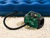 An electric air pump is connected to an inflatable mattress, inflating it on a carpeted floor. Produktbild-Vorschau