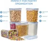 A collection of clear plastic food storage containers filled with various dry goods, arranged on a white background with marketing text and feature icons. Produktbild-Vorschau