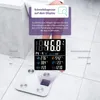 A person's legs are visible standing on a white diagnostic scale with a digital display showing body composition data. The scale is placed on a tiled floor. Anteprima dell’immagine prodotto