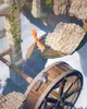 Two dragons are depicted in a fantasy setting with ancient ruins and a water wheel. Podgląd zdjęcia produktu
