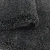 A close-up view of a dark gray shaggy rug, showing its texture and pile. Produktbild-Vorschau