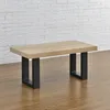 A coffee table with a wooden top and black metal legs is shown against a white brick wall and wooden floor. Anteprima dell’immagine prodotto