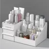 A white makeup organizer filled with various cosmetic products, placed on a flat surface against a gray background. Náhľad obrázku produktu