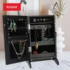 A black jewelry box with its doors open, displaying various jewelry items inside. The box is placed on a marble surface, with a vase and dried plants in the background. Produktbild-Vorschau