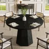 A round black dining table with four chairs set in a dining room. Produktbild-Vorschau