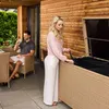 A couple on a patio with a wooden wall and a storage box. Náhľad obrázku produktu