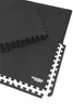 A stack of black interlocking floor mats with a white border, on a white background. Produktbild-Vorschau