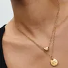 A close-up shot of a person wearing two gold necklaces. Podgląd zdjęcia produktu