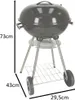 A black charcoal grill with silver legs and wheels, shown with dimensions indicated by black lines and text. Produktbild-Vorschau