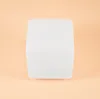 A white cube-shaped object is centered on a peach-colored background. Produktbild-Vorschau