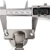 A close-up of a cabinet hinge being measured by a digital caliper. Produktbild-Vorschau