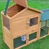 A wooden rabbit hutch with a green roof sits on a grassy lawn. Produktbild-Vorschau