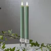 Two green LED candles in clear glass holders, with ivy branches in the foreground. Produktbild-Vorschau
