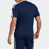 A person wearing a navy blue Adidas t-shirt and shorts. Voir les images du produit