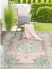 An outdoor rug on a wooden deck with a chair and cushions. Náhled obrázku produktu
