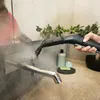 A person is using a steam cleaner to clean a bathroom faucet. Produktbild-Vorschau