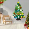 A felt Christmas tree decoration set is displayed on a wall, with a chair and a lamp in the foreground. Produktbild-Vorschau