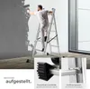 A man is painting a wall while standing on a multi-purpose ladder. Close-up shots of the ladder's feet and rungs are shown. Náhled obrázku produktu