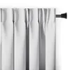 A close-up view of white blackout curtains hanging from a black curtain rod against a white wall. Produktbild-Vorschau