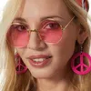 Close-up of a woman wearing large pink sunglasses and pink peace sign earrings. Produktbild-Vorschau