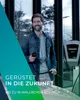 A man is holding a charging cable next to an electric vehicle charging station. Produktbild-Vorschau