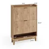 A wooden shoe cabinet with two flip drawers and an open shelf at the bottom, shown with dimensions indicated. Podgląd zdjęcia produktu