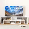 A white modular TV stand with various compartments, displaying decorative items and books, with a large TV screen showing a landscape image with hot air balloons. Náhled obrázku produktu