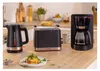 A kitchen counter with a toaster, kettle, and coffee maker, along with a plate of toast. Voir les images du produit