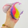 A hand holding a colorful stress ball. Produktbild-Vorschau