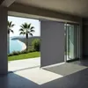 A modern patio with a view of a beach and palm trees, featuring a partially deployed gray roller blind. Náhled obrázku produktu