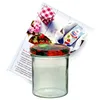A glass jar with a decorative lid, a recipe booklet, and a packet of jam-making ingredients are arranged on a white background. Produktbild-Vorschau