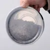 A hand holding a transparent lid of a container filled with coffee beans. Produktbild-Vorschau