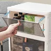 A hand is opening a transparent storage box, revealing items inside. Voir les images du produit