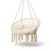 A beige macrame hanging chair with tassels and a cushion, suspended against a white background. Náhled obrázku produktu