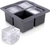 A gray silicone ice cube tray with four large square molds, two of which contain ice. A single large ice cube sits in front of the tray. Anteprima dell’immagine prodotto