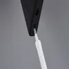 A close-up shot of a cleaning tool being inserted into the charging port of a black smartphone. Voir les images du produit