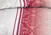 A close-up view of a red and beige seersucker duvet cover with a damask pattern. Produktbild-Vorschau